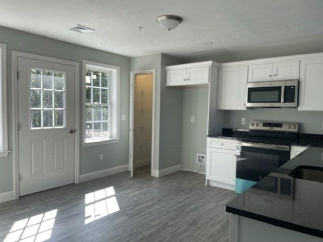 kitchen with visible vents, dark countertops, appliances with stainless steel finishes, and white cabinets