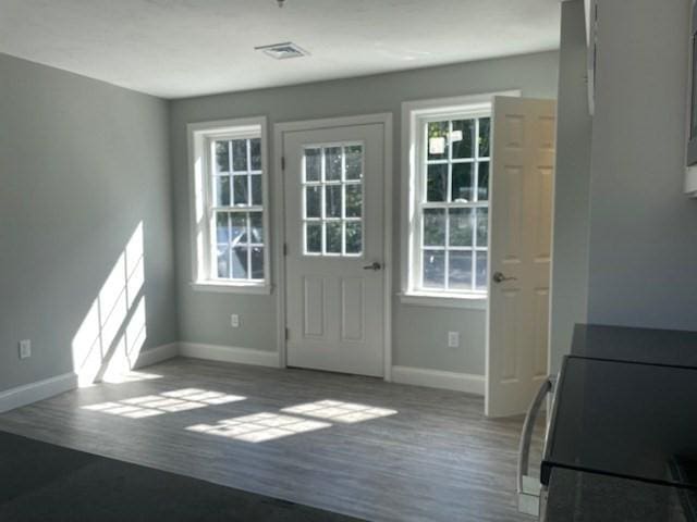 doorway featuring visible vents, wood finished floors, and baseboards