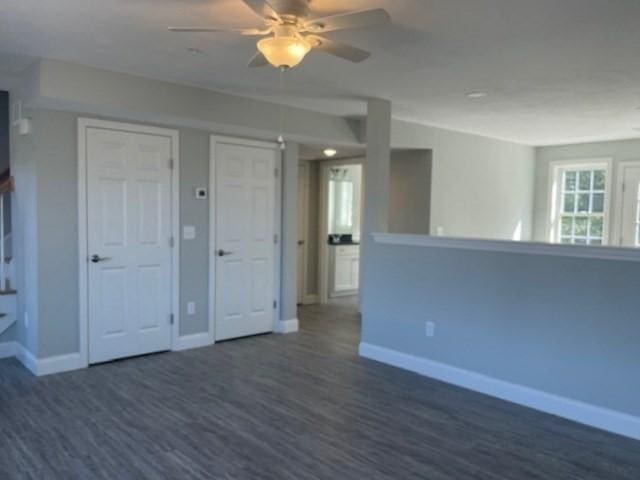 unfurnished room featuring dark wood-type flooring, baseboards, and ceiling fan