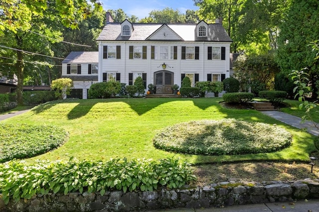 view of front of home with a front lawn and a chimney