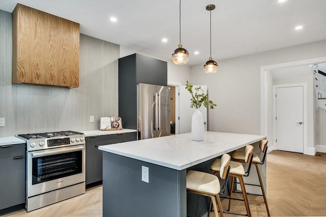 kitchen featuring a breakfast bar area, a center island, stainless steel appliances, recessed lighting, and gray cabinetry
