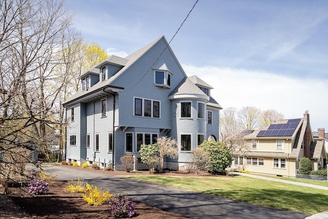 victorian-style house with a front lawn