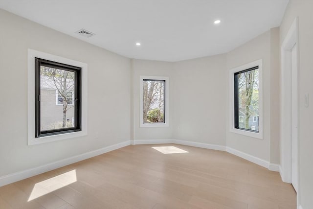 empty room with recessed lighting, visible vents, a healthy amount of sunlight, and light wood-type flooring