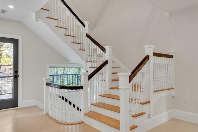 stairway featuring visible vents, recessed lighting, baseboards, and lofted ceiling