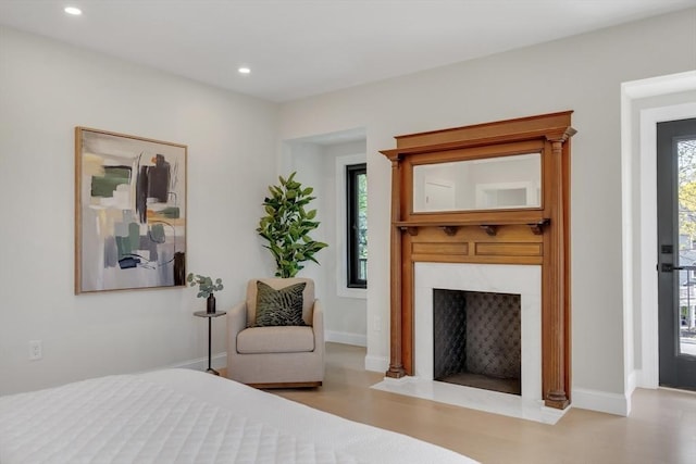 bedroom featuring baseboards, recessed lighting, and a premium fireplace