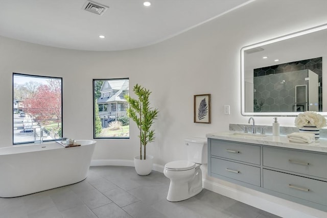 bathroom with visible vents, a tile shower, vanity, baseboards, and toilet
