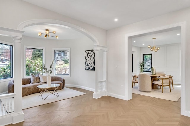sitting room featuring an inviting chandelier, arched walkways, decorative columns, and recessed lighting