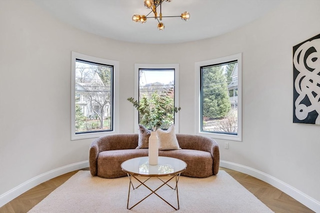 sitting room with baseboards and a chandelier