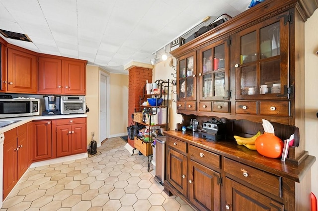 6 Cedar Pond Dr, Sturbridge, MA 01566 - kitchen with stainless steel microwave, light tile patterned floors, and glass insert cabinets