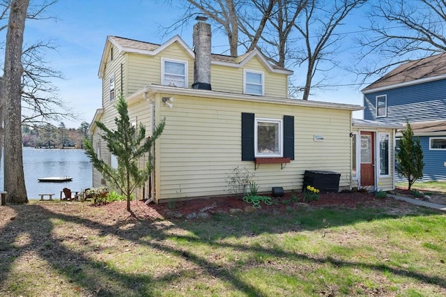 6 Cedar Pond Dr, Sturbridge, MA 01566 - rear view of house featuring a chimney, a lawn, and a water view