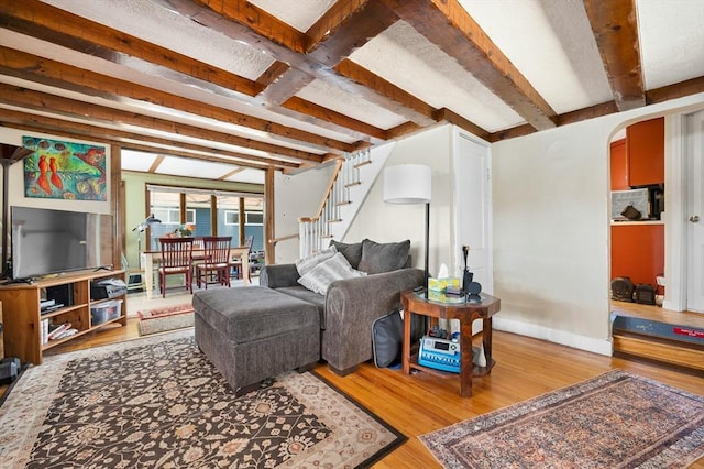 6 Cedar Pond Dr, Sturbridge, MA 01566 - living area featuring wood finished floors, arched walkways, stairway, and beam ceiling