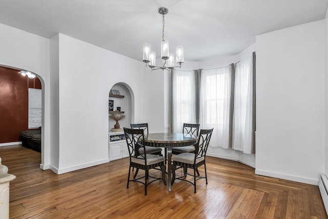 39 High, Haverhill, MA 01832 - dining space featuring arched walkways, a chandelier, wood finished floors, and baseboard heating