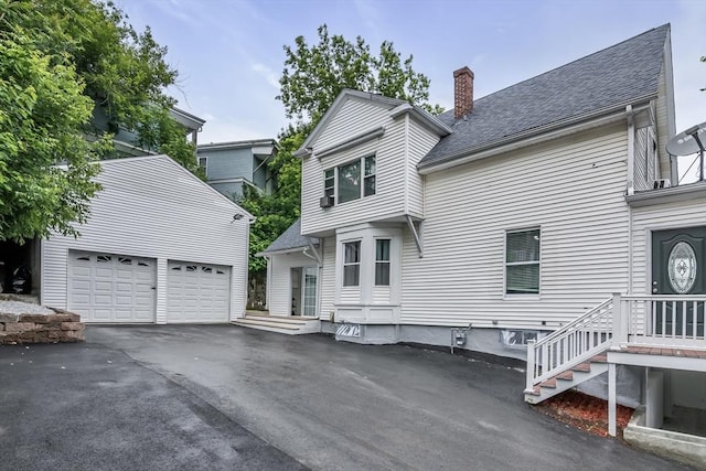 39 High, Haverhill, MA 01832 - back of property with an outbuilding, a chimney, driveway, a shingled roof, and a garage