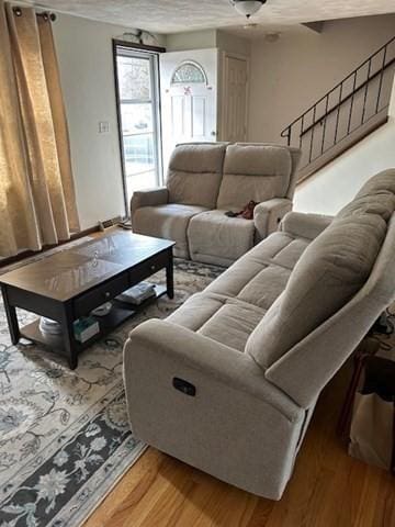 living room featuring stairway and light wood-style flooring