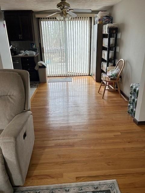 living area with light wood finished floors and a ceiling fan