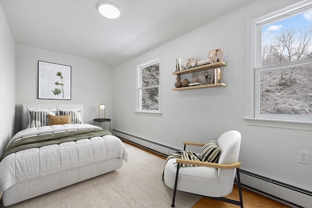 bedroom featuring wood-type flooring and a baseboard radiator