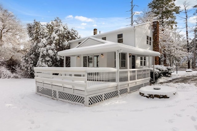 snow covered rear of property with a wooden deck