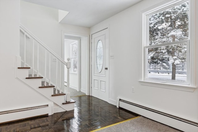 entrance foyer with baseboard heating and dark parquet floors