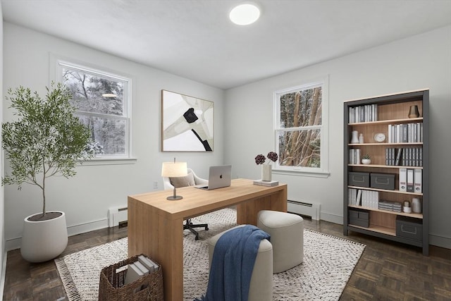 home office with dark parquet flooring, a wealth of natural light, and a baseboard radiator