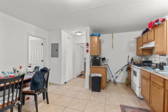 15 Russell St, Worcester, MA 01609 - kitchen with white range with electric stovetop, under cabinet range hood, electric panel, light countertops, and light tile patterned floors