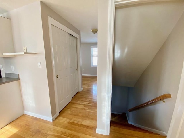 hallway featuring baseboards and light wood-style floors