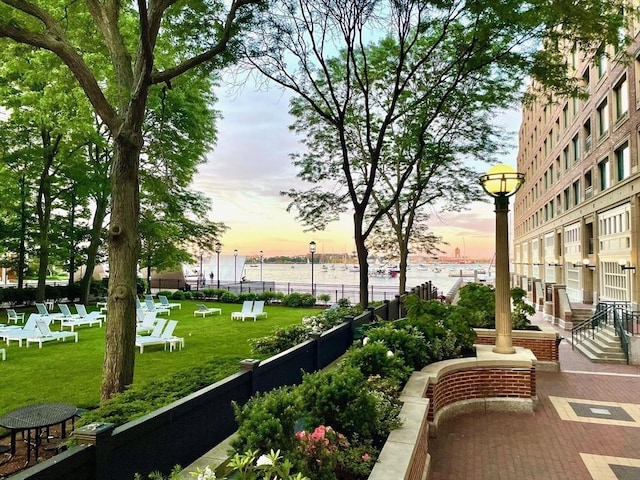 view of home's community featuring a water view and a yard