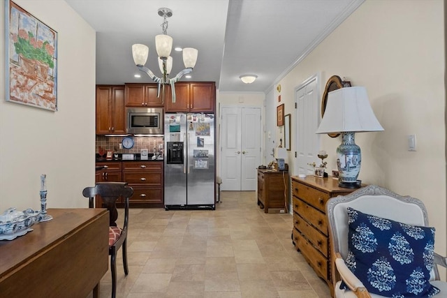 kitchen featuring pendant lighting, decorative backsplash, ornamental molding, appliances with stainless steel finishes, and a chandelier