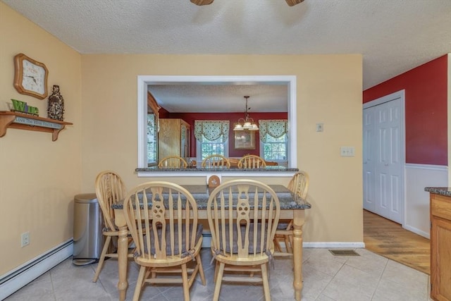50 Kienia Rd, Hudson, NH 03051 - dining space with a baseboard heating unit, a textured ceiling, tile patterned floors, a chandelier, and baseboards