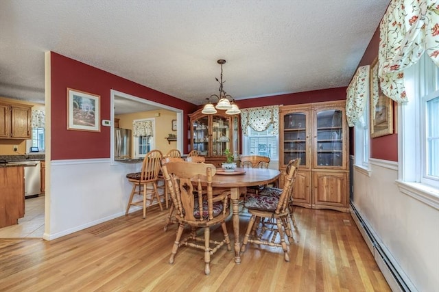 50 Kienia Rd, Hudson, NH 03051 - dining area featuring a chandelier, a textured ceiling, light wood-style floors, baseboard heating, and baseboards
