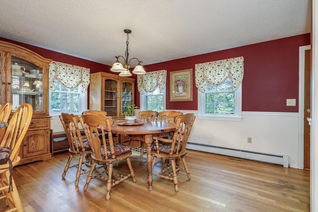 50 Kienia Rd, Hudson, NH 03051 - dining space with a baseboard radiator, a chandelier, a textured ceiling, and light wood-style floors