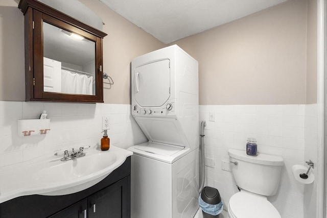 151 W 6th St Unit 1, Boston, MA 02127 - full bath featuring estacked washer and dryer, tile walls, vanity, toilet, and a wainscoted wall