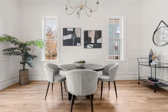 dining area with a chandelier, light hardwood / wood-style floors, and a wealth of natural light