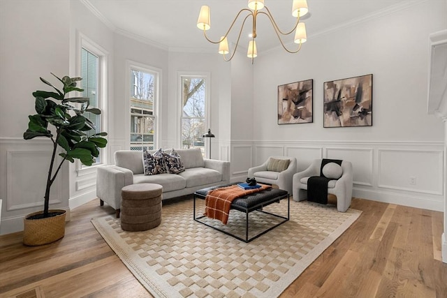 living room featuring hardwood / wood-style flooring, an inviting chandelier, and ornamental molding