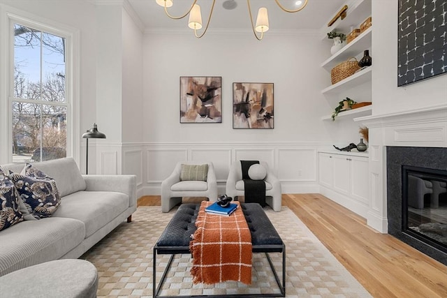 living room with plenty of natural light, light wood-type flooring, and ornamental molding