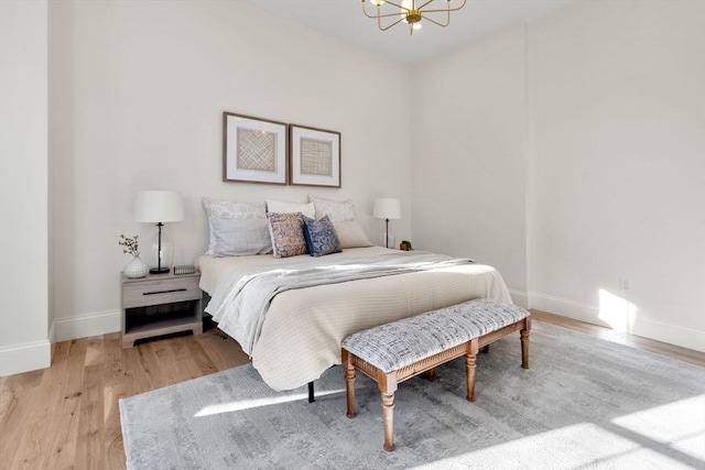 bedroom featuring a notable chandelier and light wood-type flooring