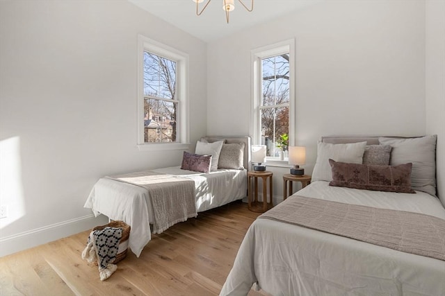 bedroom featuring light hardwood / wood-style floors and an inviting chandelier