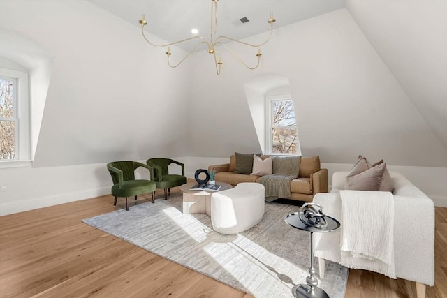 living room featuring hardwood / wood-style floors, vaulted ceiling, and a wealth of natural light