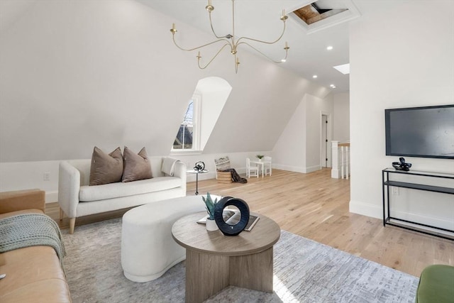 living room featuring light wood-type flooring, lofted ceiling, and a notable chandelier