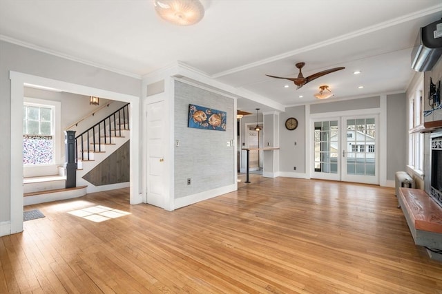 unfurnished living room with crown molding, ceiling fan, light hardwood / wood-style floors, and a wealth of natural light