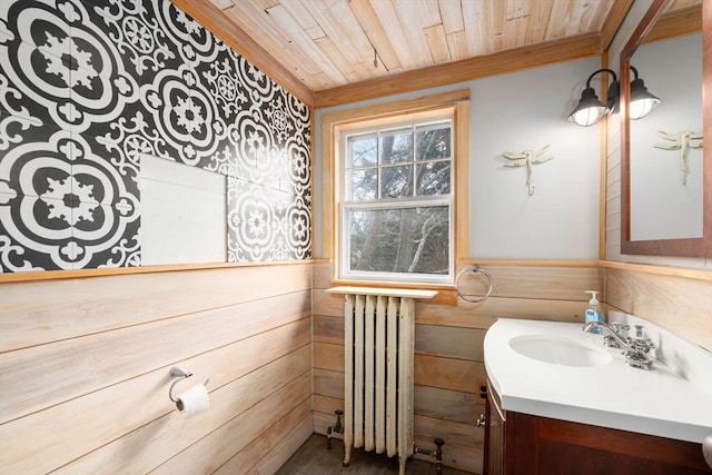 bathroom featuring vanity, radiator, wooden ceiling, and wood walls