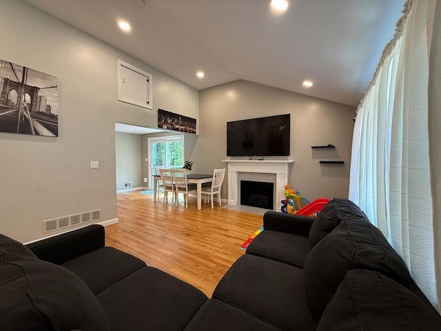 1 Fieldstone Way, Hopedale, MA 01747 - living room with light wood-type flooring, vaulted ceiling, a fireplace with flush hearth, recessed lighting, and baseboards