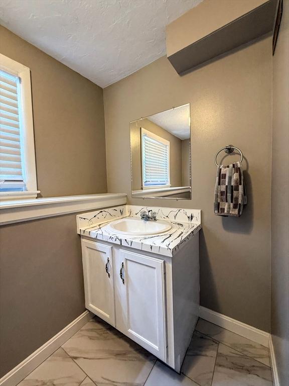 1 Fieldstone Way, Hopedale, MA 01747 - bathroom with marble finish floors, baseboards, vanity, and a textured ceiling