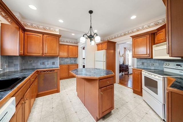 kitchen featuring white appliances, dark countertops, a kitchen island, and brown cabinets