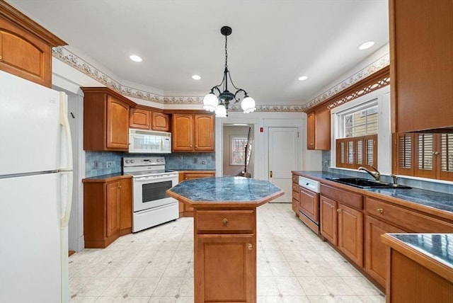 kitchen with brown cabinets, dark countertops, a kitchen island, a sink, and white appliances