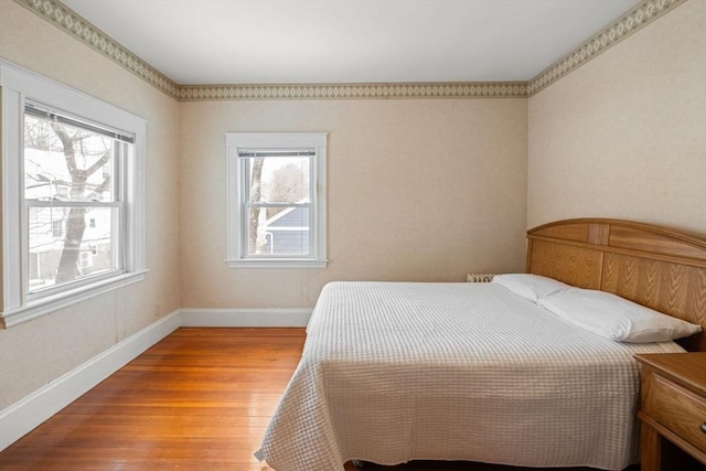 bedroom with baseboards and wood finished floors