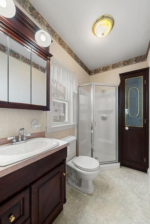 bathroom featuring toilet, a shower stall, and vanity