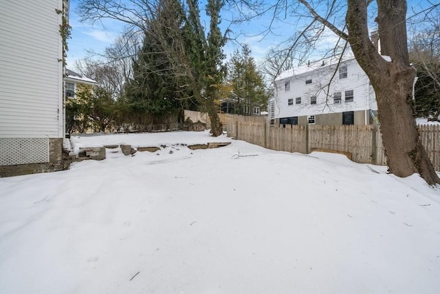 yard layered in snow featuring fence