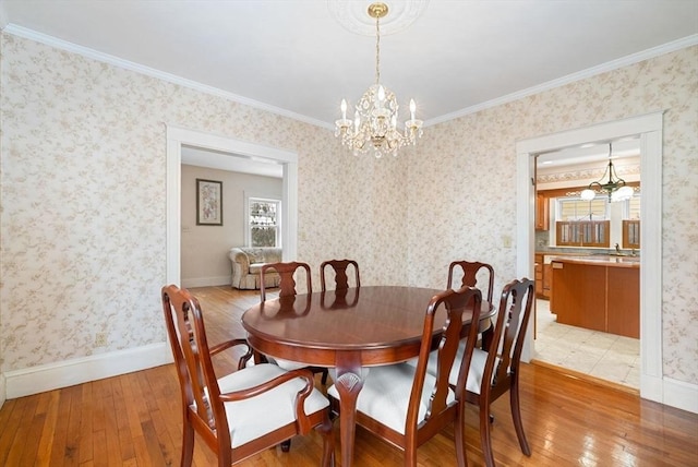 dining room with a notable chandelier, light wood-type flooring, and wallpapered walls