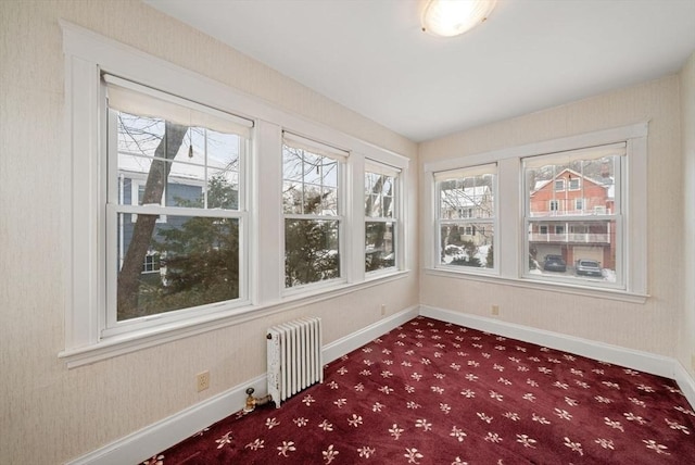 unfurnished sunroom featuring radiator heating unit