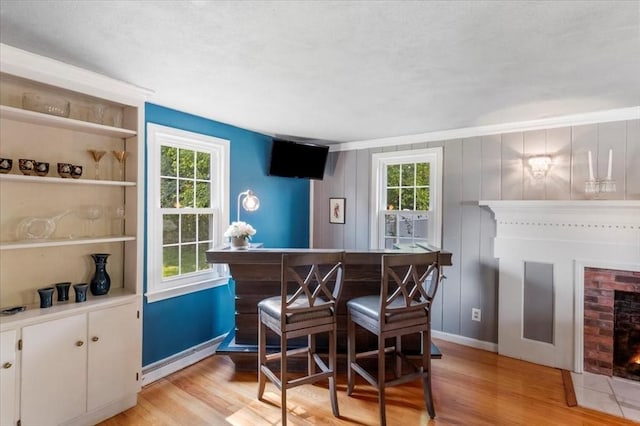 7 Scenic Dr, Wilbraham, MA 01095 - indoor dry bar featuring a brick fireplace, light wood-style flooring, and a textured ceiling